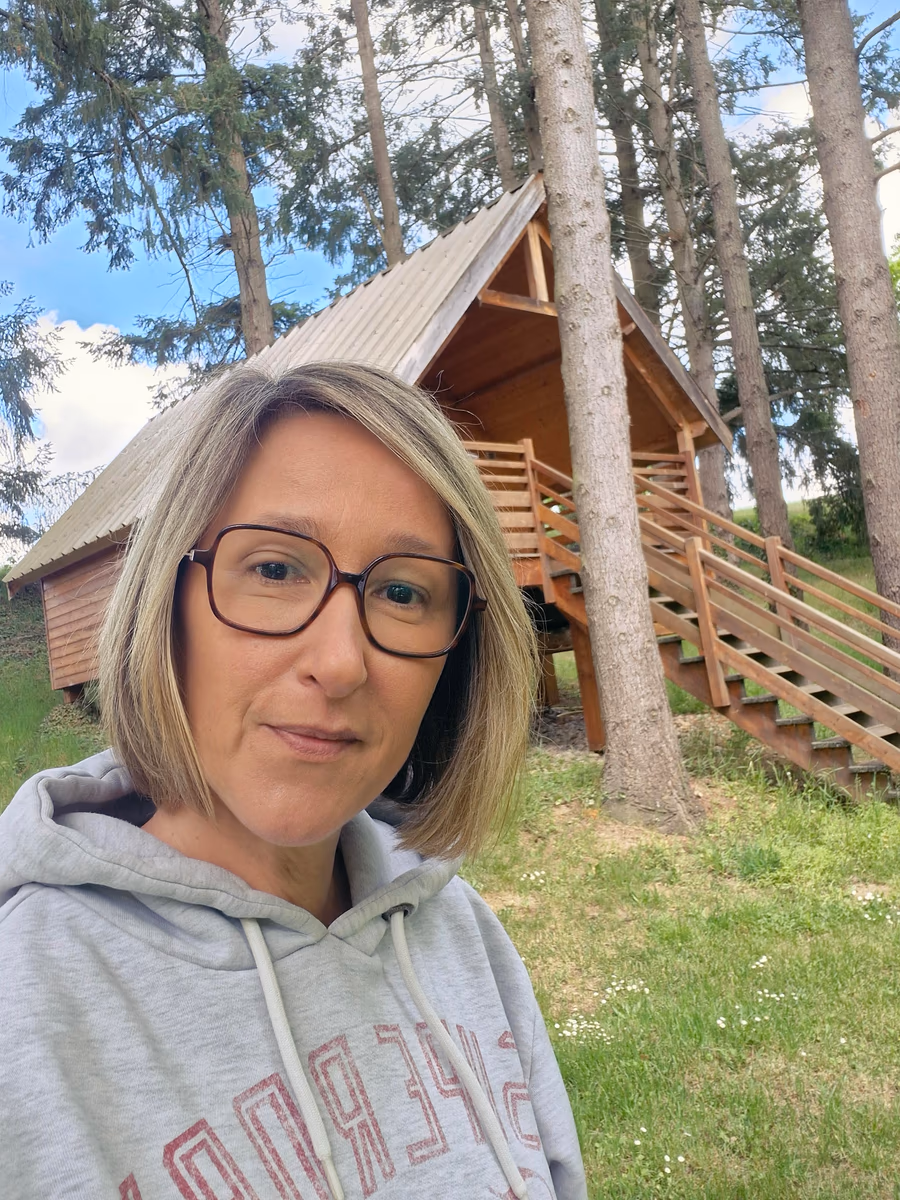 Céline Soulard devant une cabane en bois de la Petite Sapinière